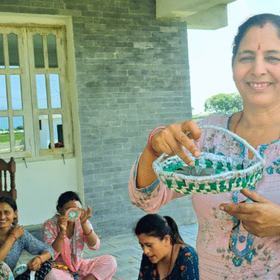 A participant from Saral Nepal's handicraft training proudly showcasing her creation made from waste plastics.
